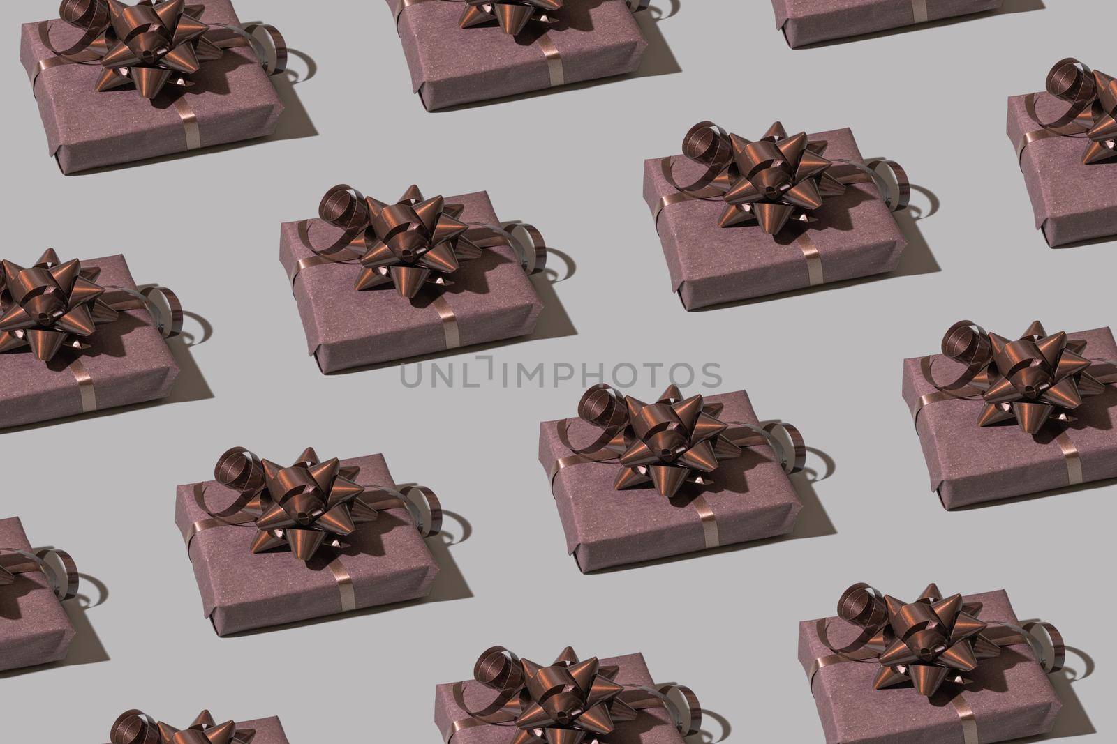 Brown gift box pattern with bow on gray background. Christmas minimalist concept photo. High quality photo
