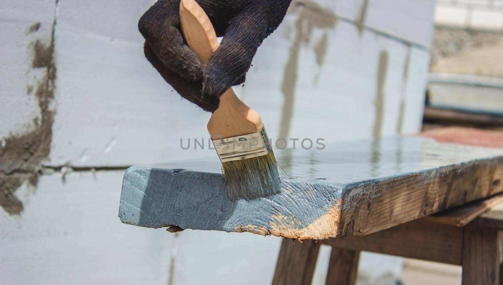 A hand with a brush that paints a tree gray. selective focus
