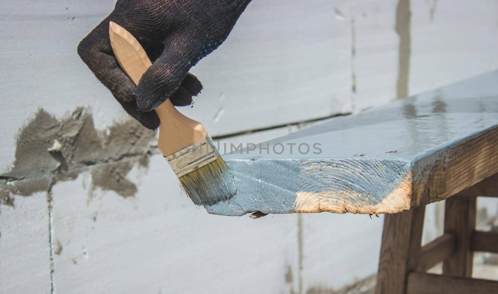 A hand with a brush that paints a tree gray. selective focus