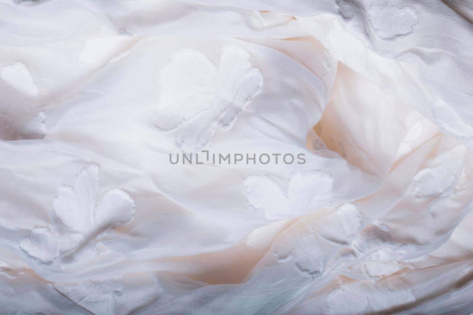 White texture with flowers. Highly detailed closeup of crumpled textile.