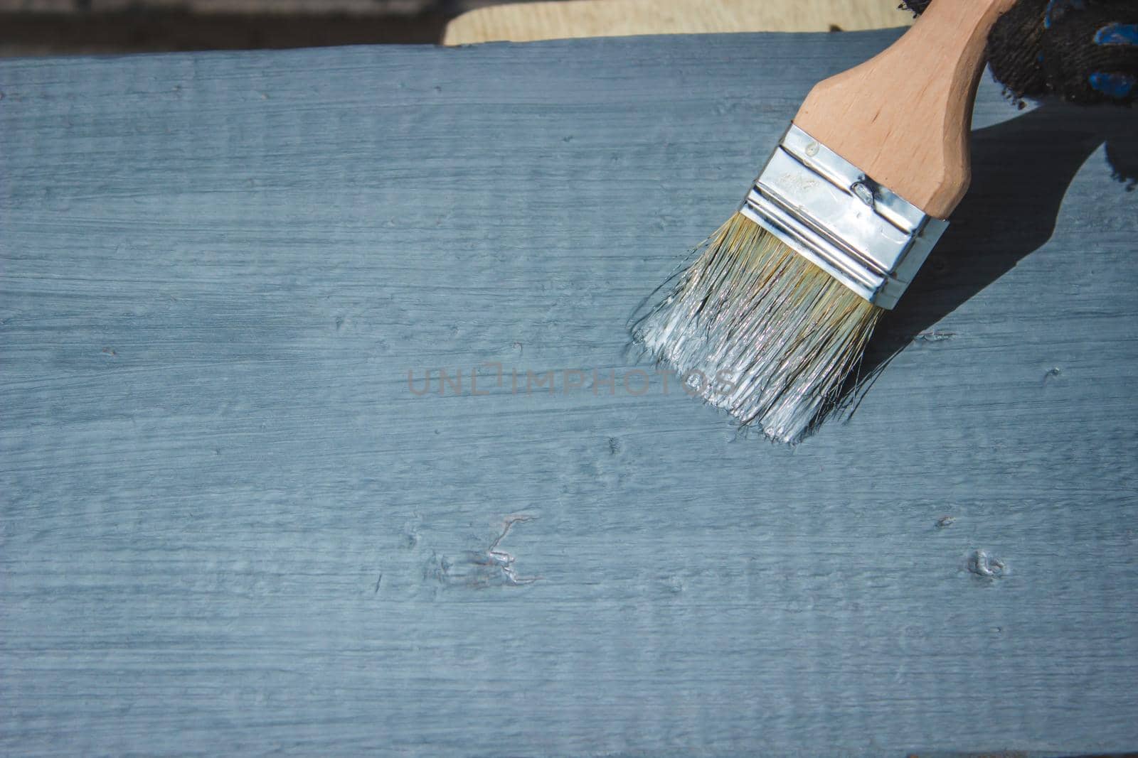 A hand with a brush that paints a tree gray. selective focus