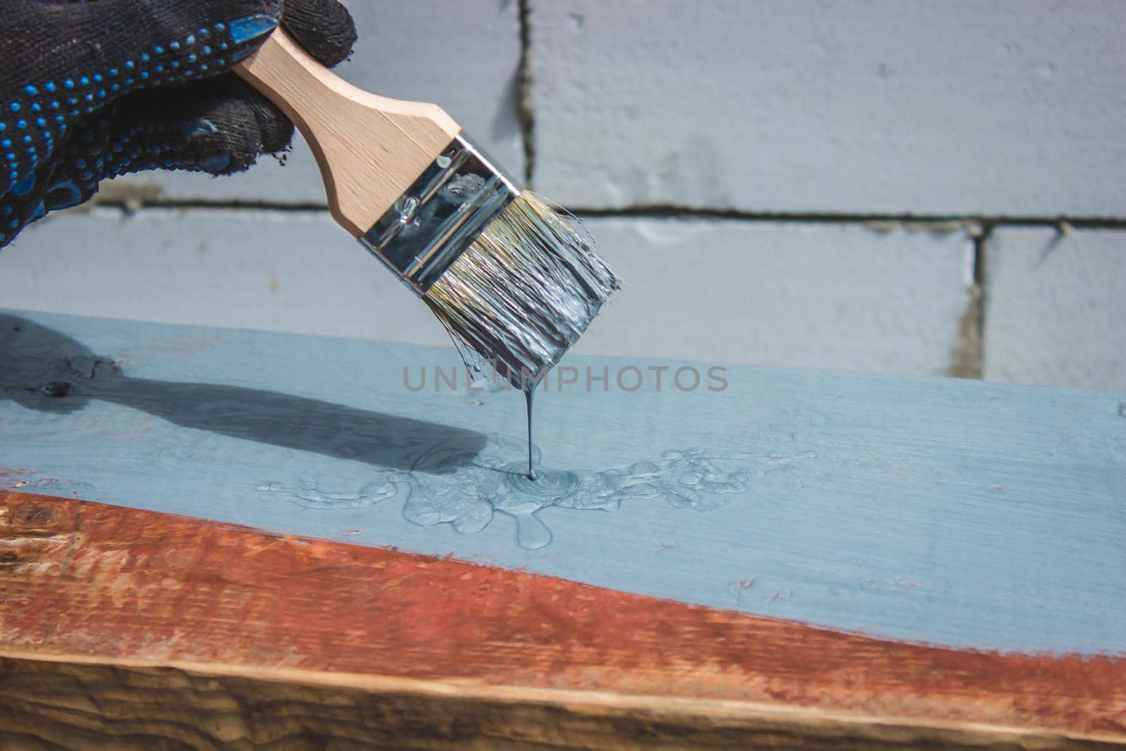 A hand with a brush that paints a tree gray. selective focus