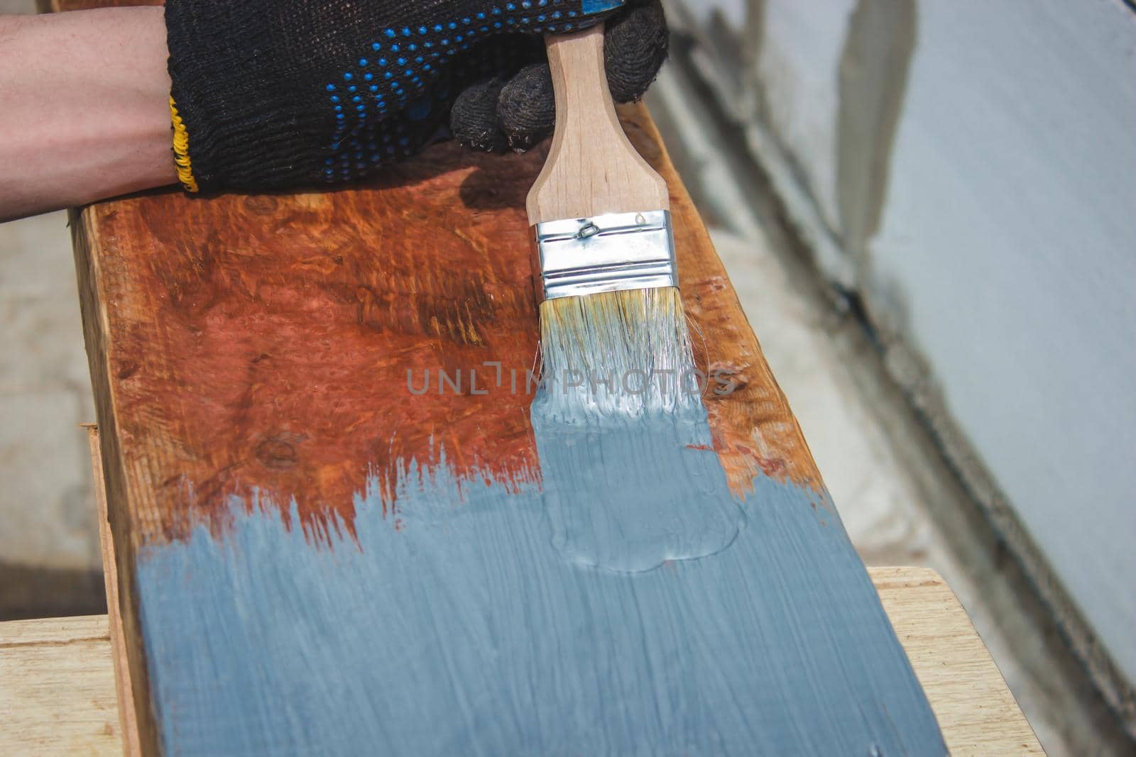 A hand with a brush that paints a tree gray. selective focus