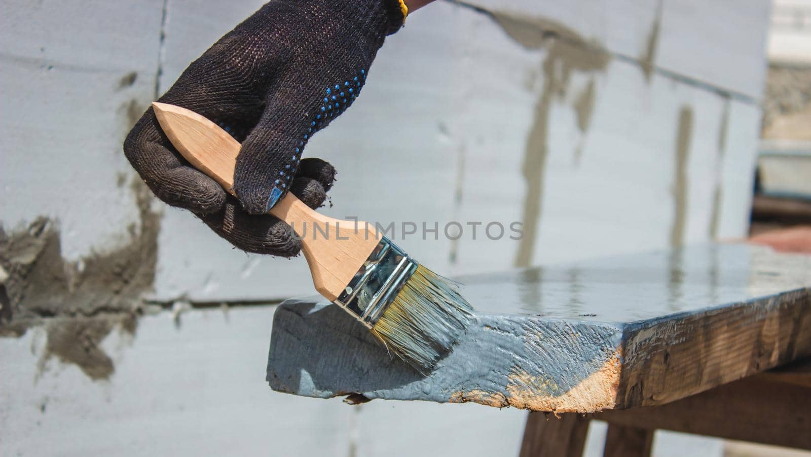 A hand with a brush that paints a tree gray. selective focus