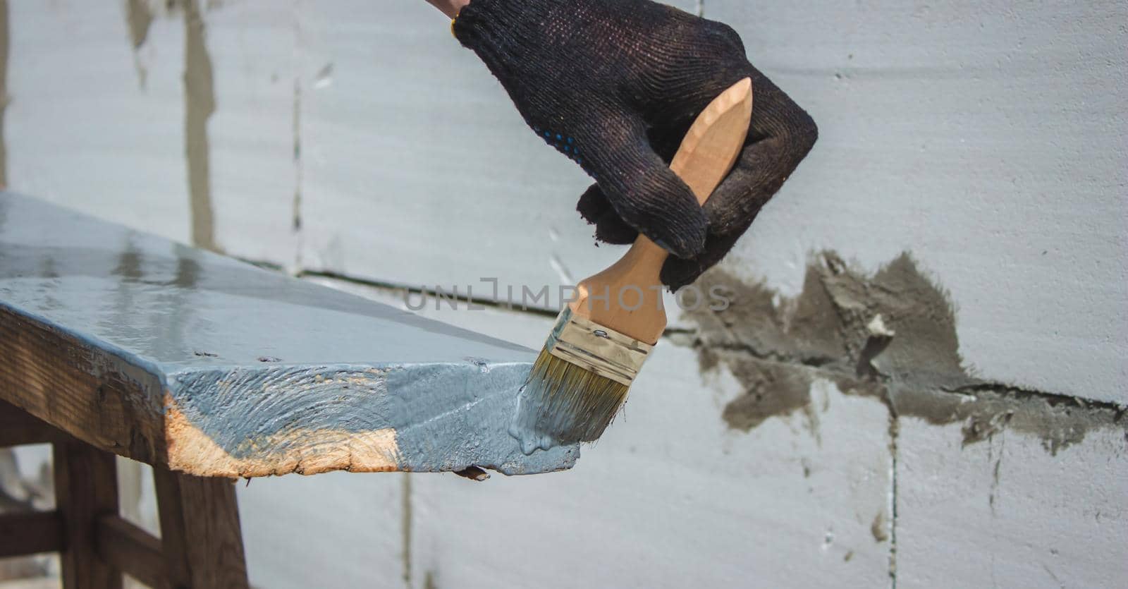 A hand with a brush that paints a tree gray. selective focus