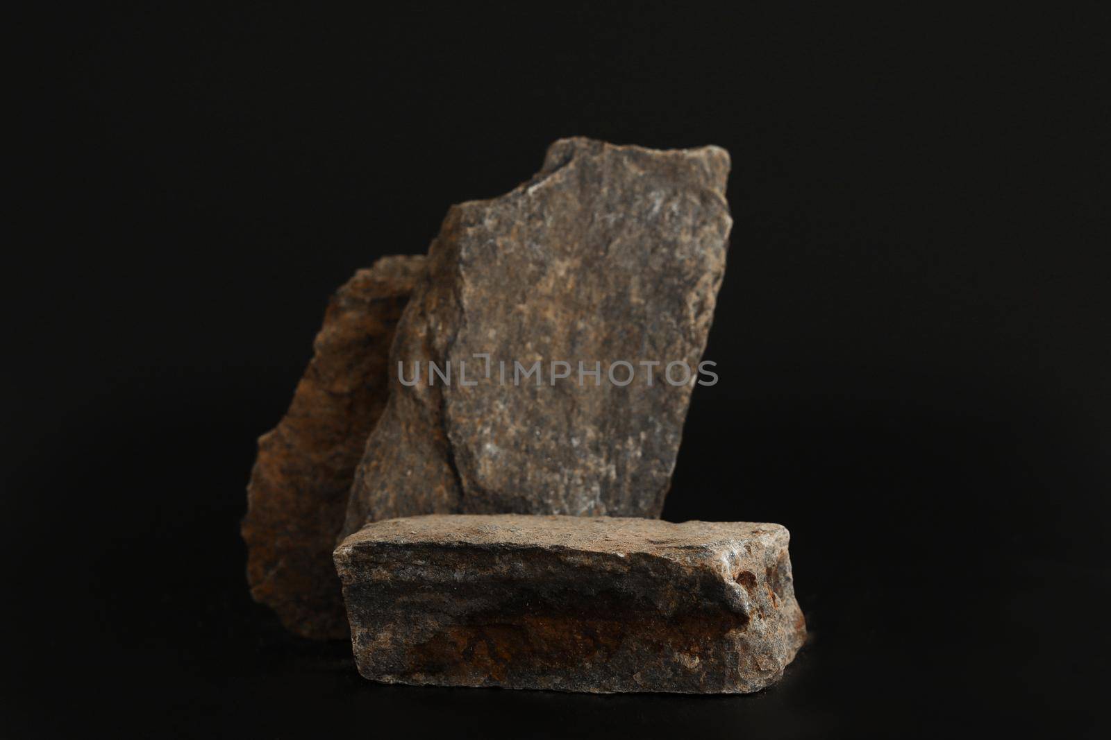Rock podium on the black background. Stone podest for product, cosmetic presentation. Creative mock up. Pedestal or platform for beauty products. by creativebird