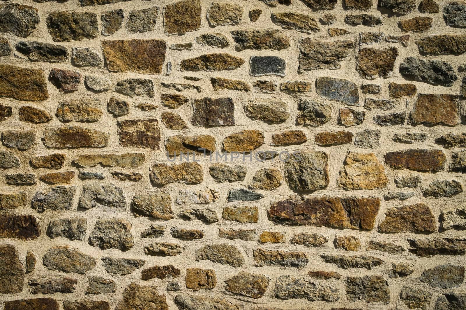 View of old wall built with stones in warm tones. Concept for backgrounds and textures.