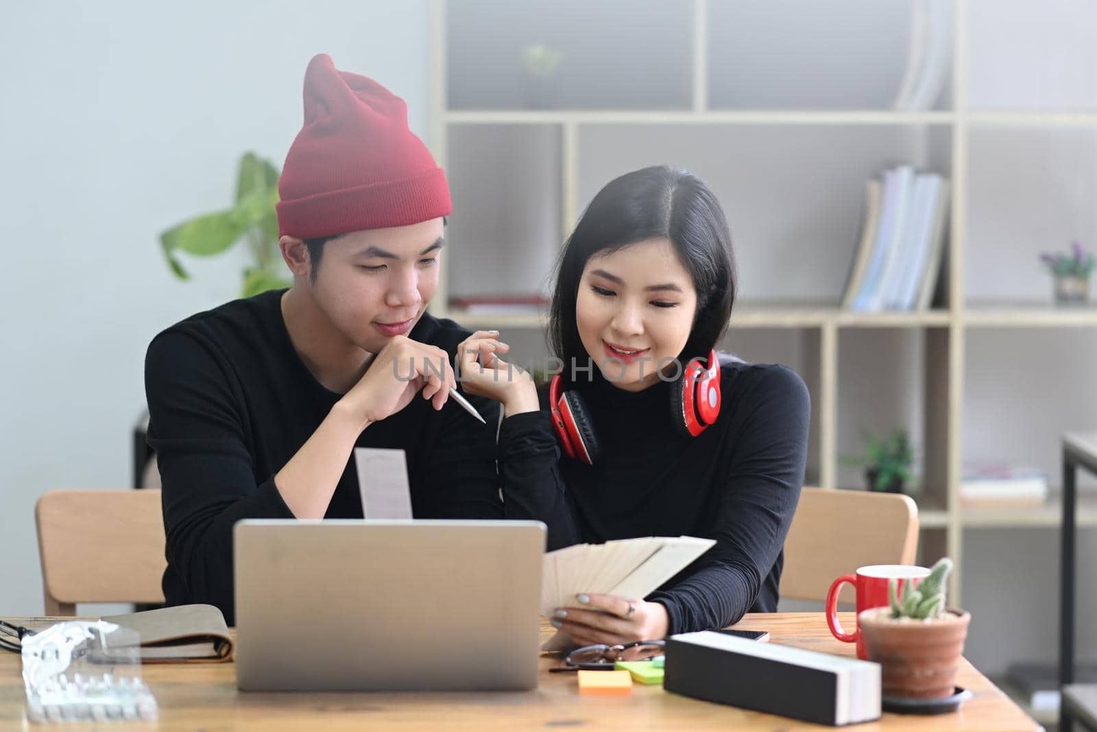 Two creative designer working together with computer laptop in modern workplace.