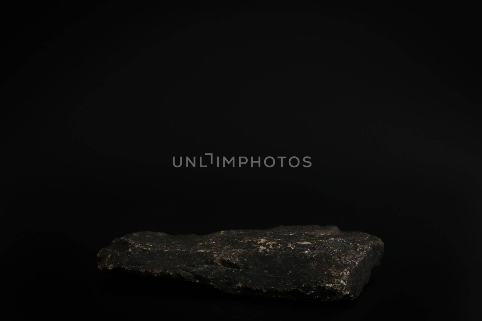 Rock podium on the black background. Stone podest for product, cosmetic presentation. Creative mock up. Pedestal or platform for beauty products. by creativebird