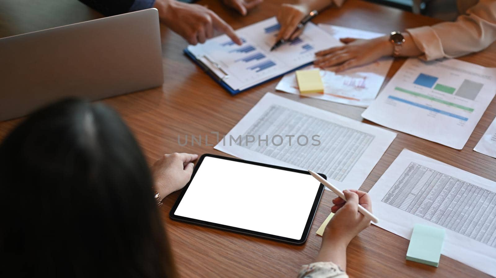 Group of successful businesspeople analyzing financial documents together. by prathanchorruangsak