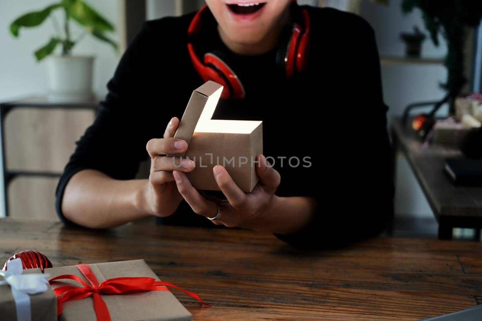 Excited young man opening Christmas gift box.