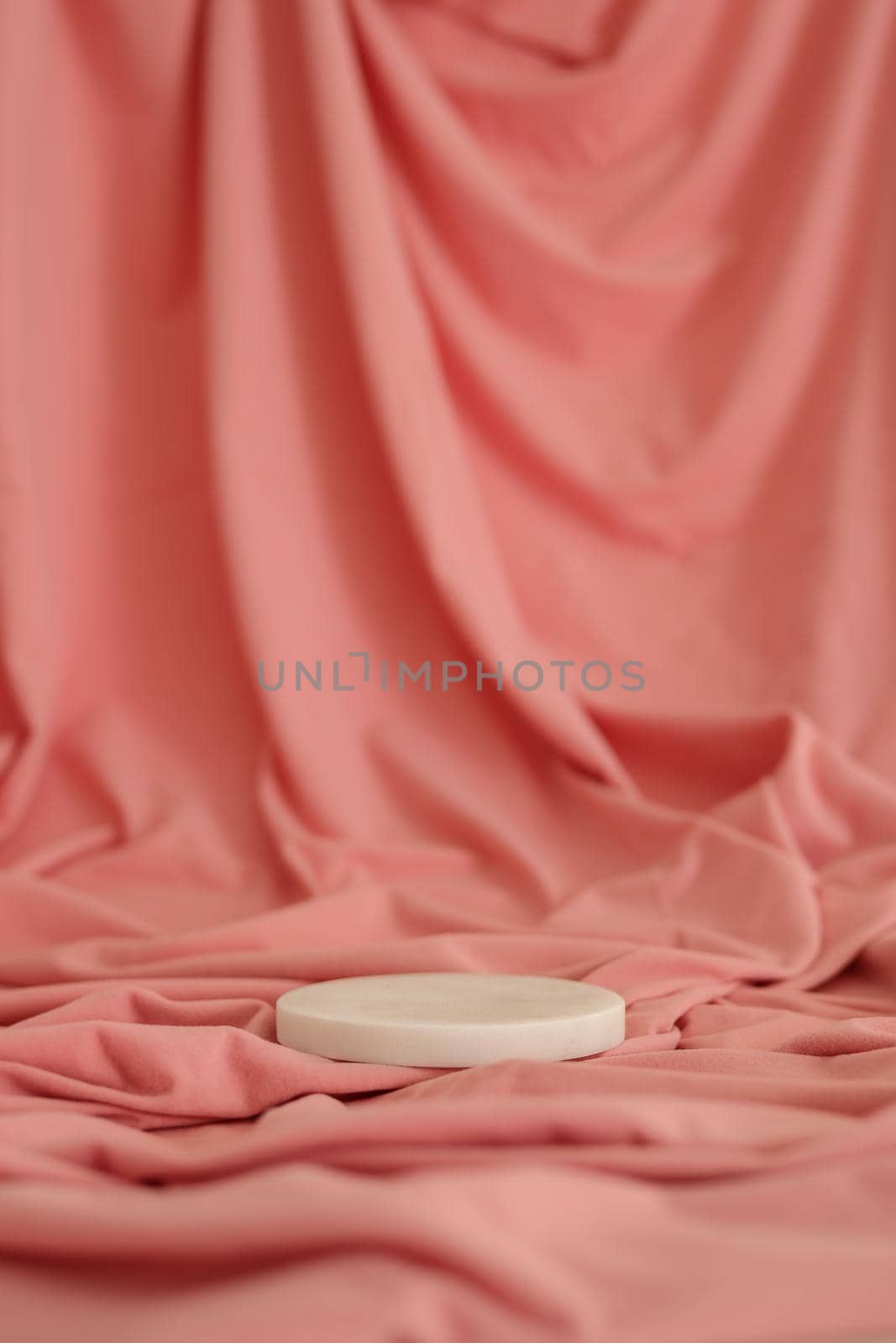 White marble podium on the pink background. Podium for product, cosmetic presentation. Creative mock up. Pedestal or platform for beauty products. Minimalist design, verical view.
