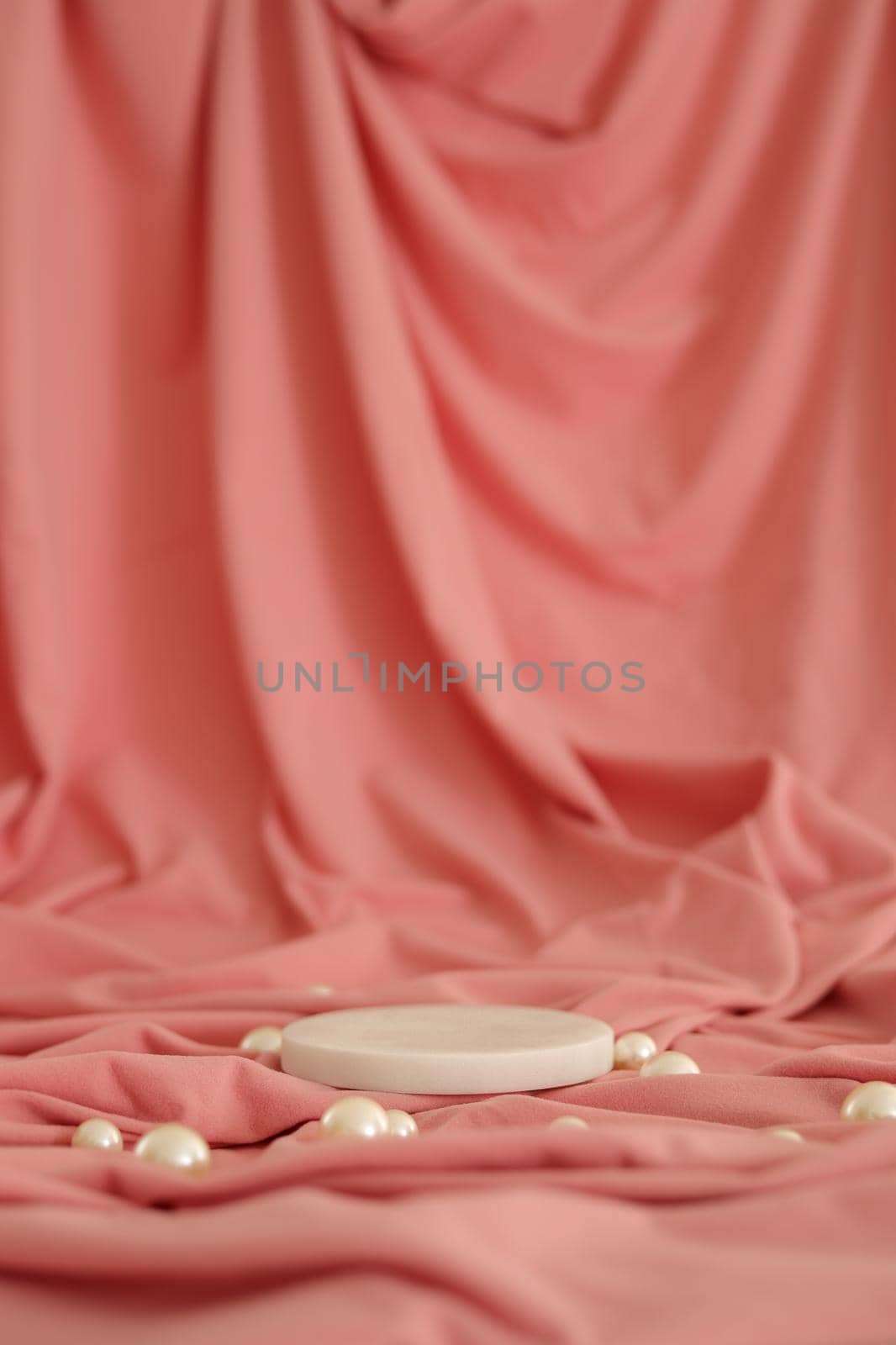 White marble podium on the pink background with pearls. Podium for product, cosmetic presentation. Creative mock up. Pedestal or platform for beauty products. Minimalist design, vertical view.