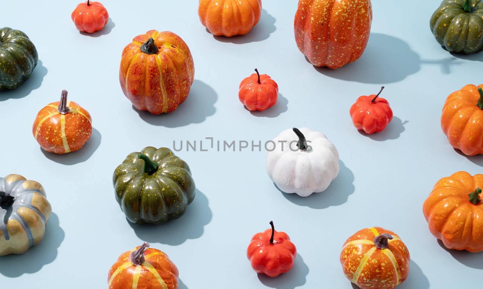 Pumpkin pattern, decorative pumpkins on a blue background high angle view. Autumn, fall, halloween concept. Trend shadow.