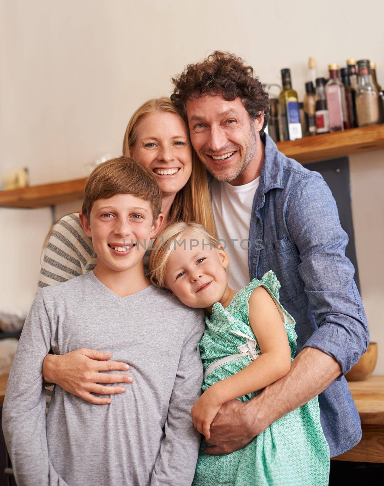 A family to be proud of. A cropped portrait of a happy family standing in their kitchen at home. by YuriArcurs