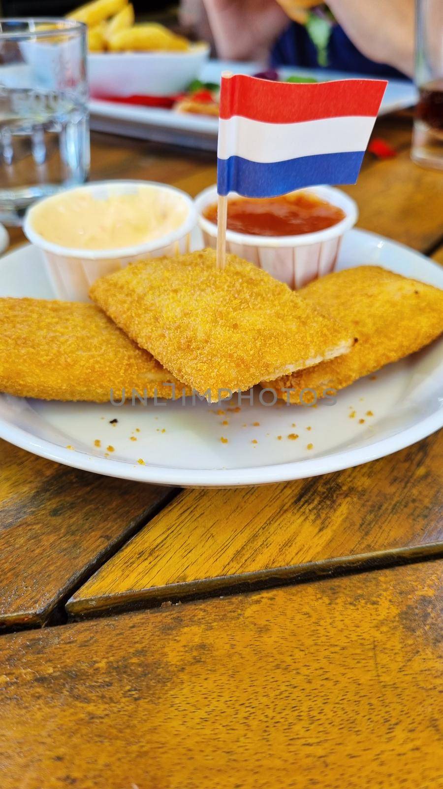 Roasted cheese sticks on a plate with Netherlands flag.