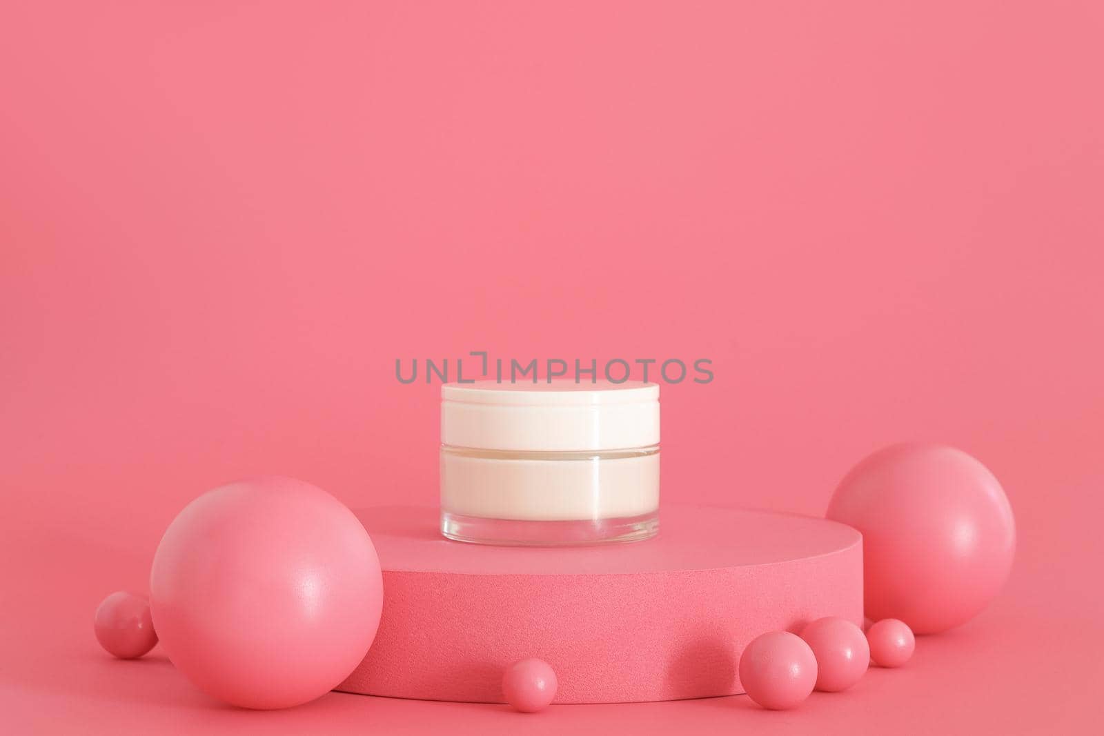 Cosmetic cream packaging standing on pink podium. Cream presentation on the pink background. Mockup