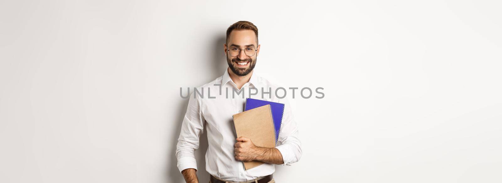Young handsome man holding notebooks, concept of e-learning and courses.