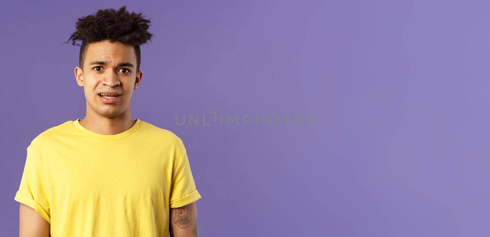 Waist-up portrait of young concerned hispanic man with worried gaze looking at camera, frowning being scared for friend stuck in troublesome situation, want help, stand purple background by Benzoix