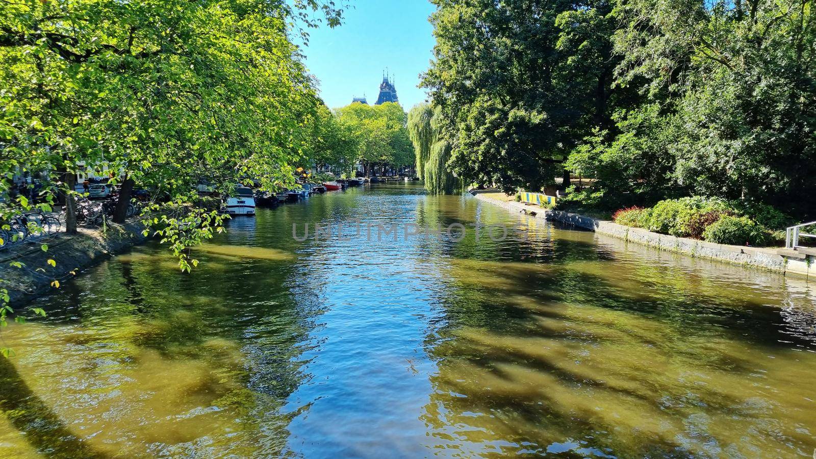 Channel in Amsterdam Netherlands. Houses river Amstel landmark. Old European city summer landscape.