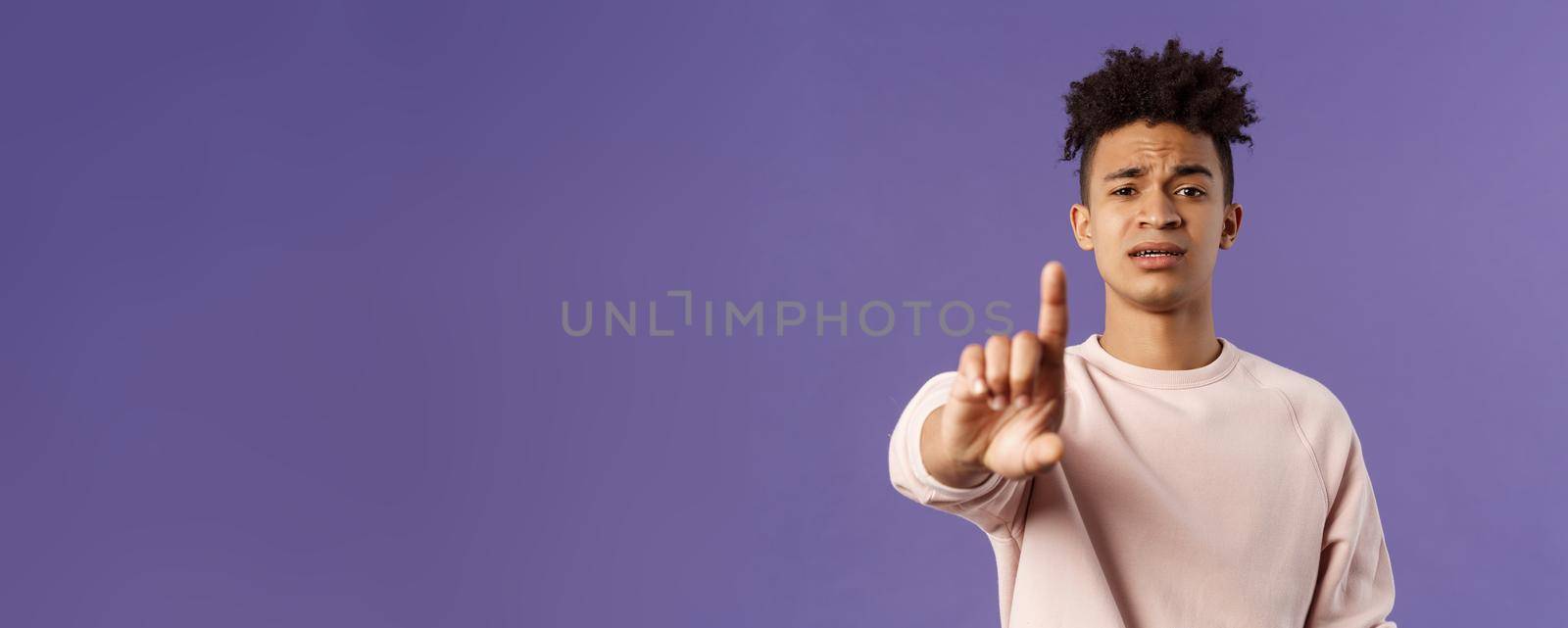 Close-up portrait of serious-looking hispanic man trying to prevent something bad, steping in for person being bullied, shaking index finger to scold wrong behavrious, forbid and prohibit something.