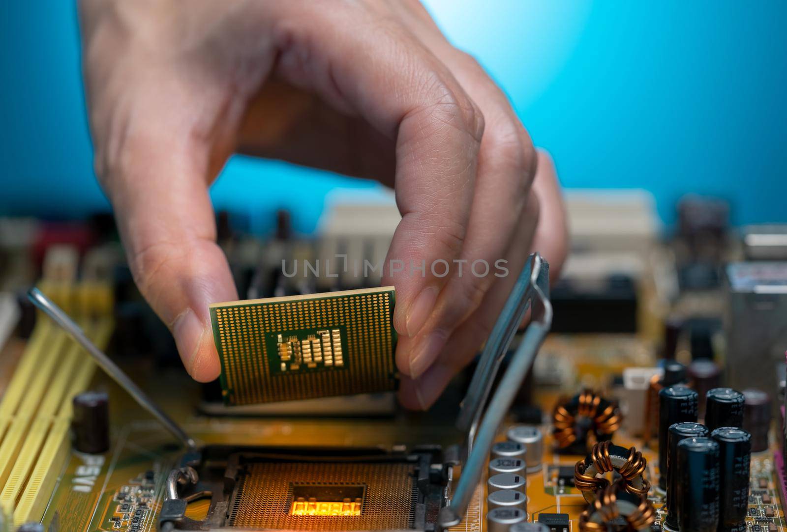 Electronic engineer hand putting computer chip on socket. Chipset on electronic circuit board of PC mother board. CPU chip. Electronic components. Computer hardware. Upgrade computer processor chip. by Fahroni