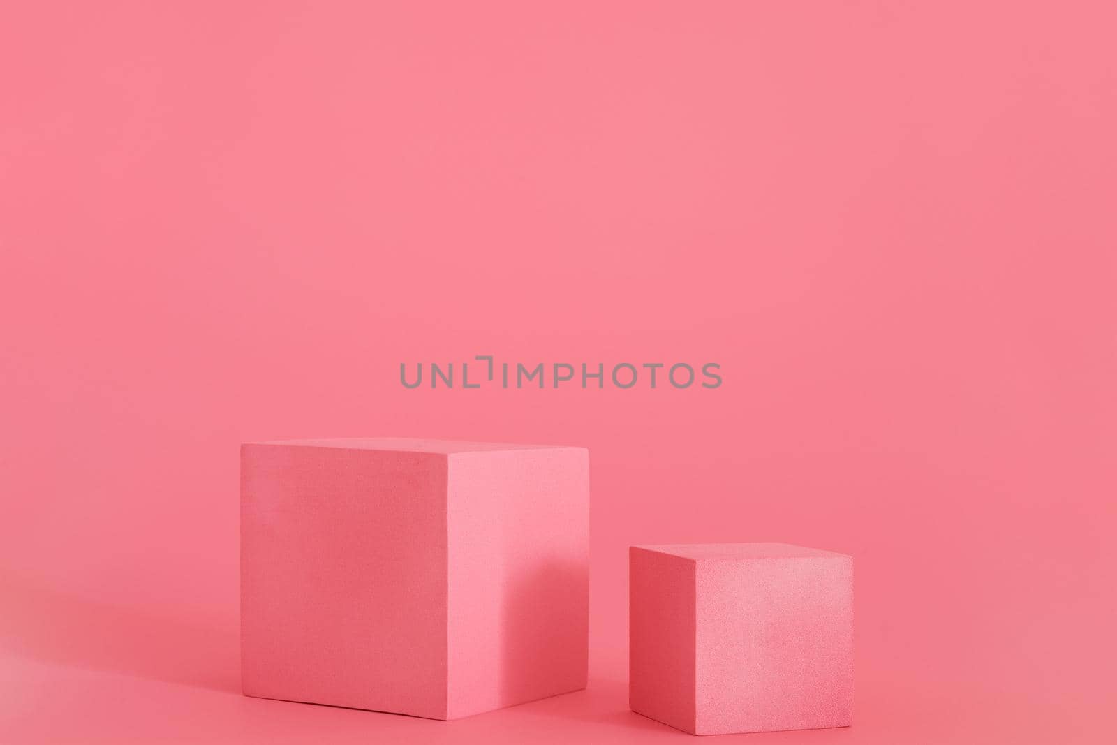 Two pink podiums on the pink background. Podium for product, cosmetic presentation. Creative mock up. Pedestal or platform for beauty products.