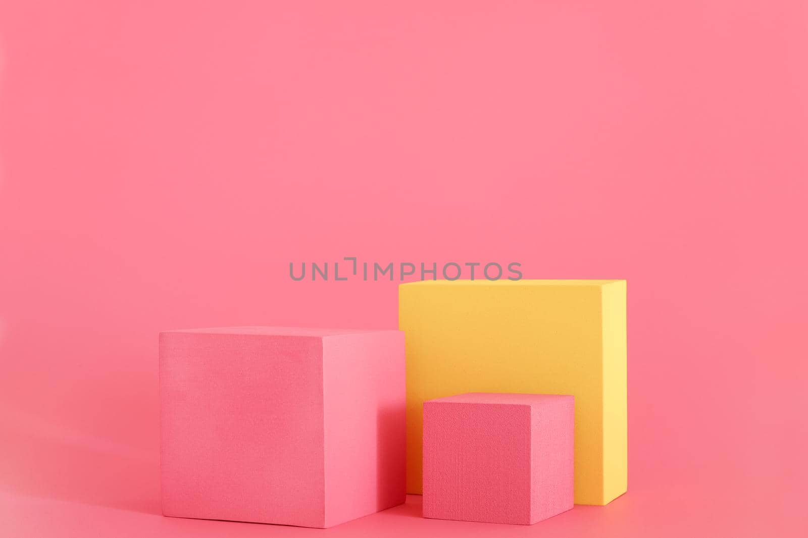 Pink and yellow podium on the pink background. Podium for product, cosmetic presentation. Creative mock up. Pedestal or platform for beauty products