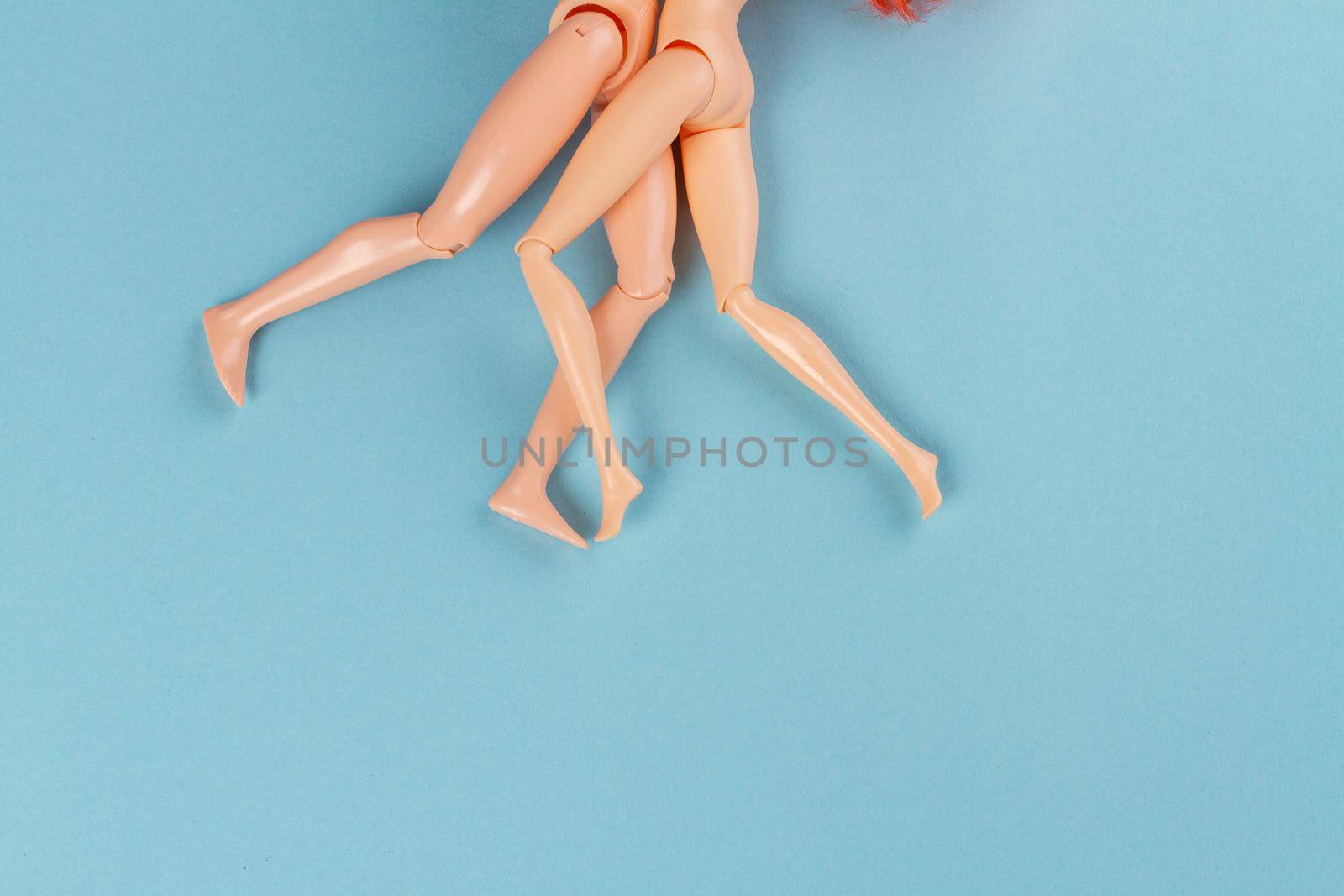 Pair of naked doll bodies on blue background. by super_picture