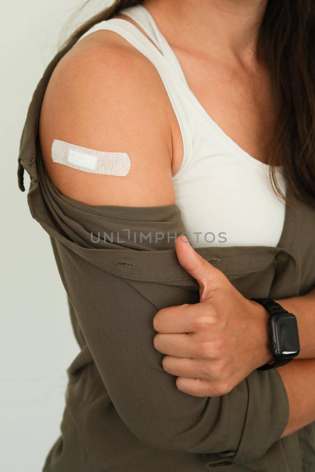 Coronavirus vaccination advertisement. Vaccinated woman showing arm with plaster bandage after Covid-19 vaccine injection. Concept of recommended inoculation, vaccination, vaccinated patient, vaccine. Close up.
