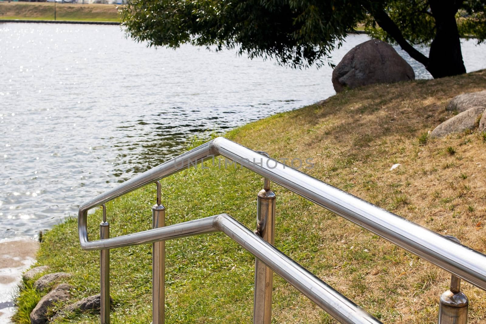 Metal railings at the stairs near the pond close up