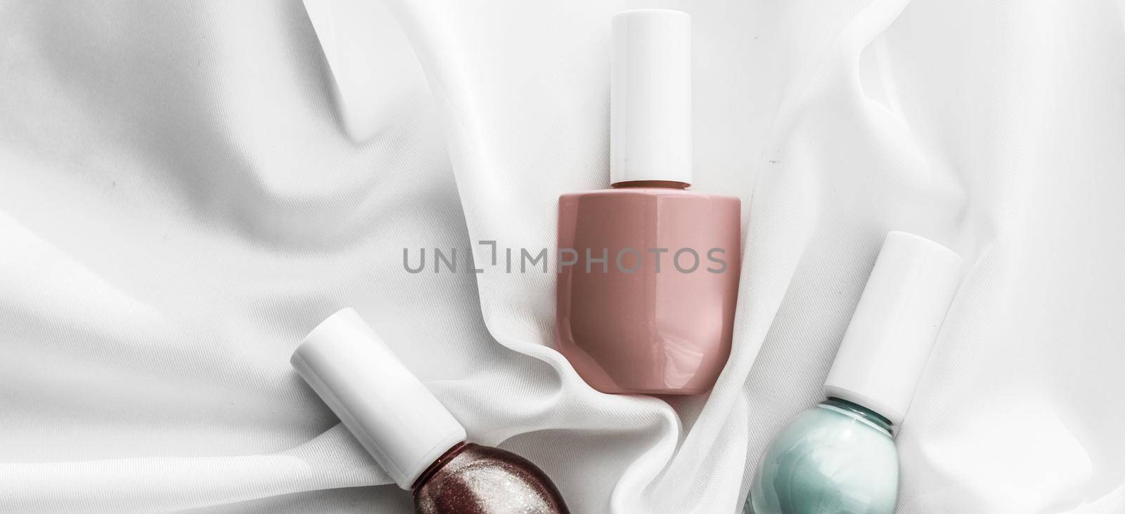 Cosmetic branding, salon and glamour concept - Nail polish bottles on silk background, french manicure products and nailpolish make-up cosmetics for luxury beauty brand and holiday flatlay art design