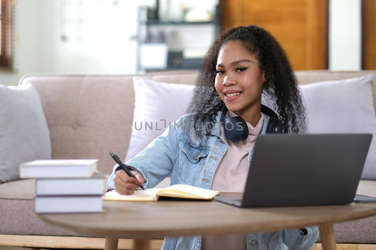 Portrait of happy female student with dark skin smiling at camera. cheerful African American hipster girl enjoying e learning and preparation to course work.