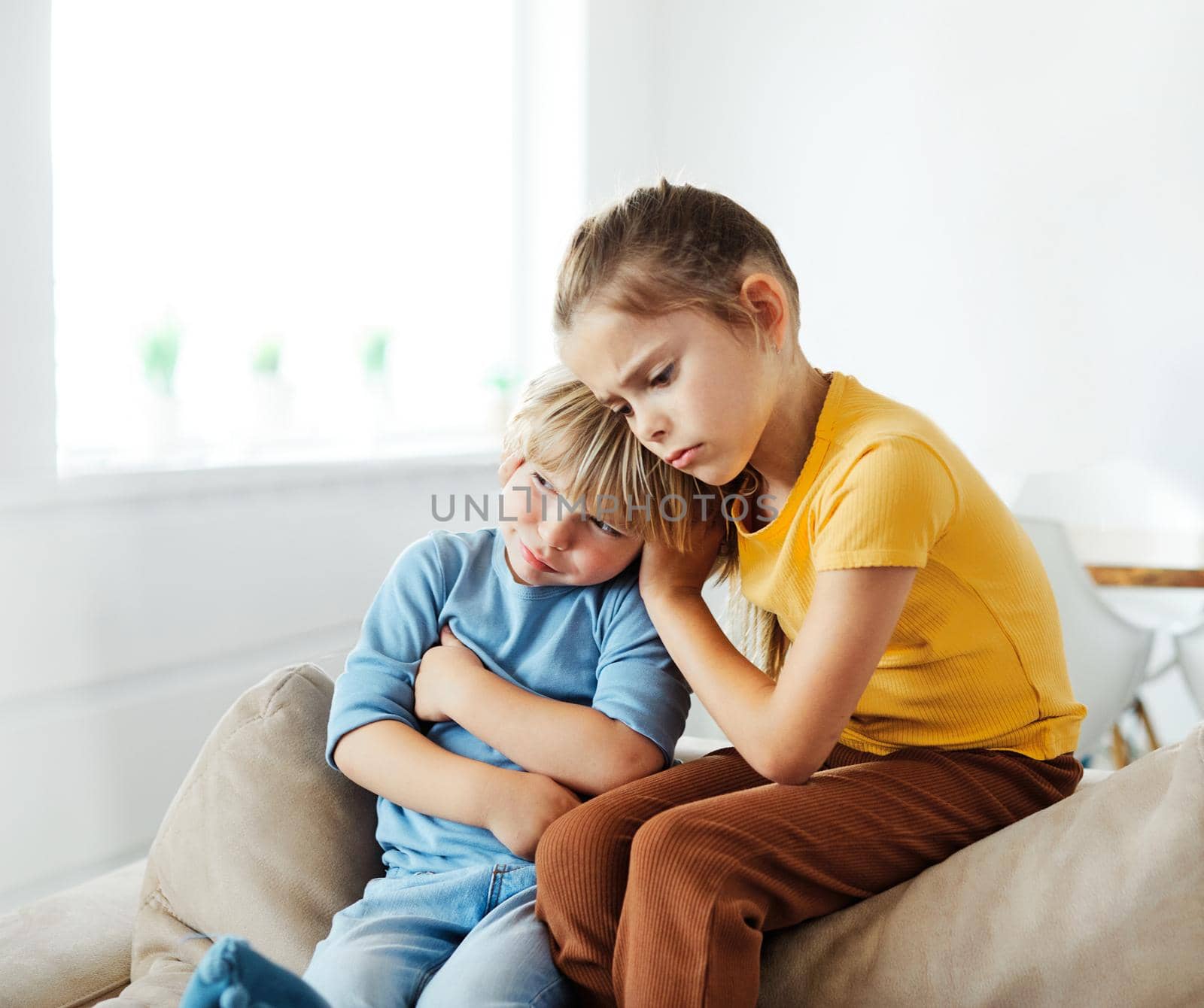 Portrait of a sad children, brother and sister, while parents are having an argument at home