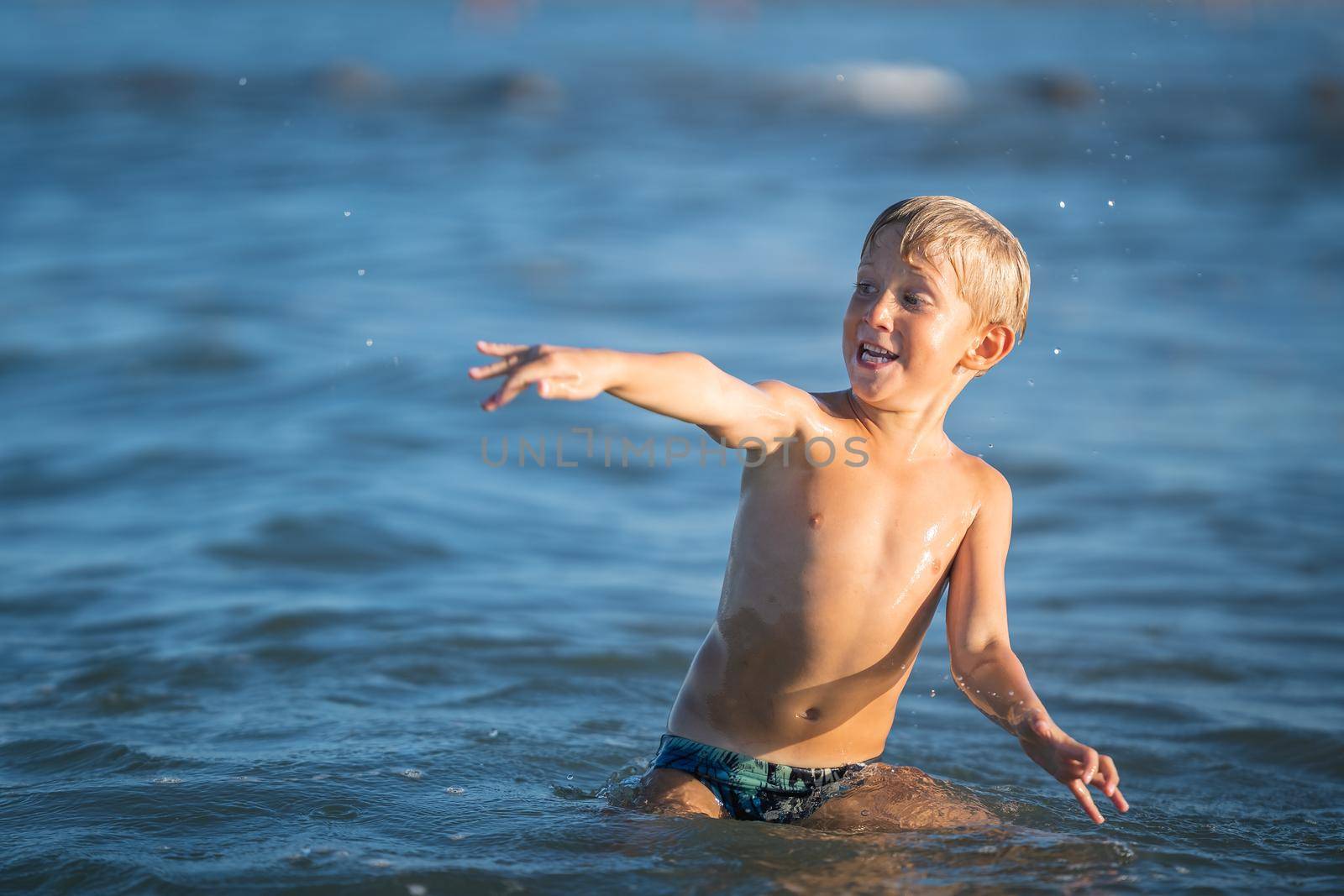 Kid playing on the sea, happy child enjoying on the beach resort, summer concept holiday, Emilia Romagna, Italy.