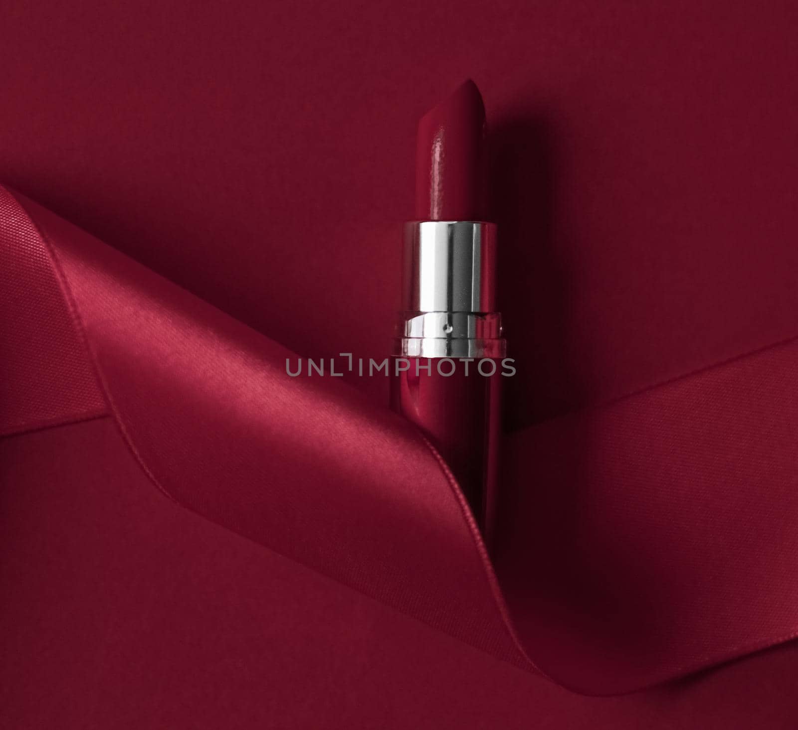 Cosmetic branding, glamour lip gloss and shopping sale concept - Luxury lipstick and silk ribbon on maroon holiday background, make-up and cosmetics flatlay for beauty brand product design