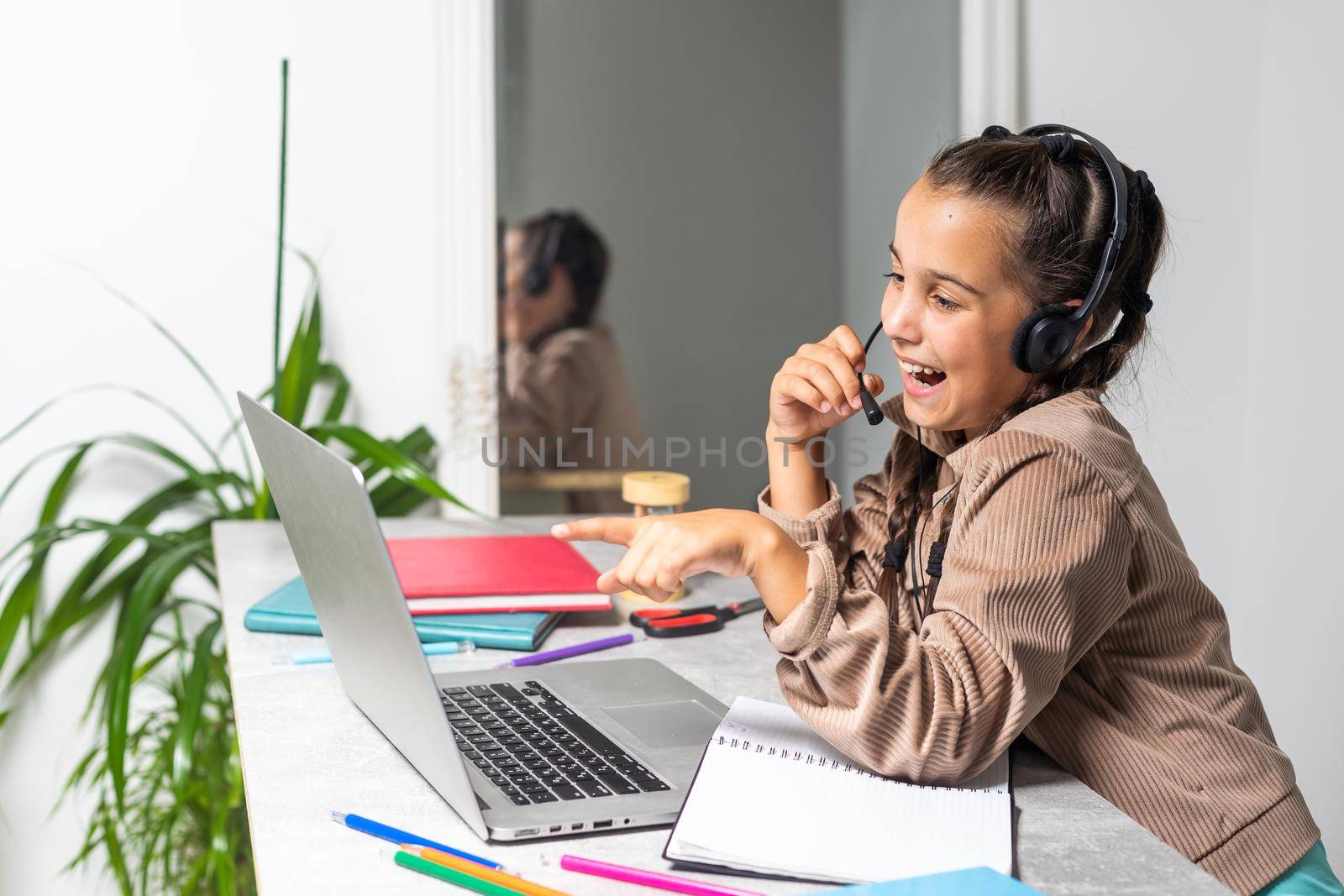 Online Education. Cute little Girl Study At Home With Laptop And Wireless Headphones, Adorable Kid Having Web Lesson With Teacher, Enjoying Distance Learning During Quarantine Time, Free Space.