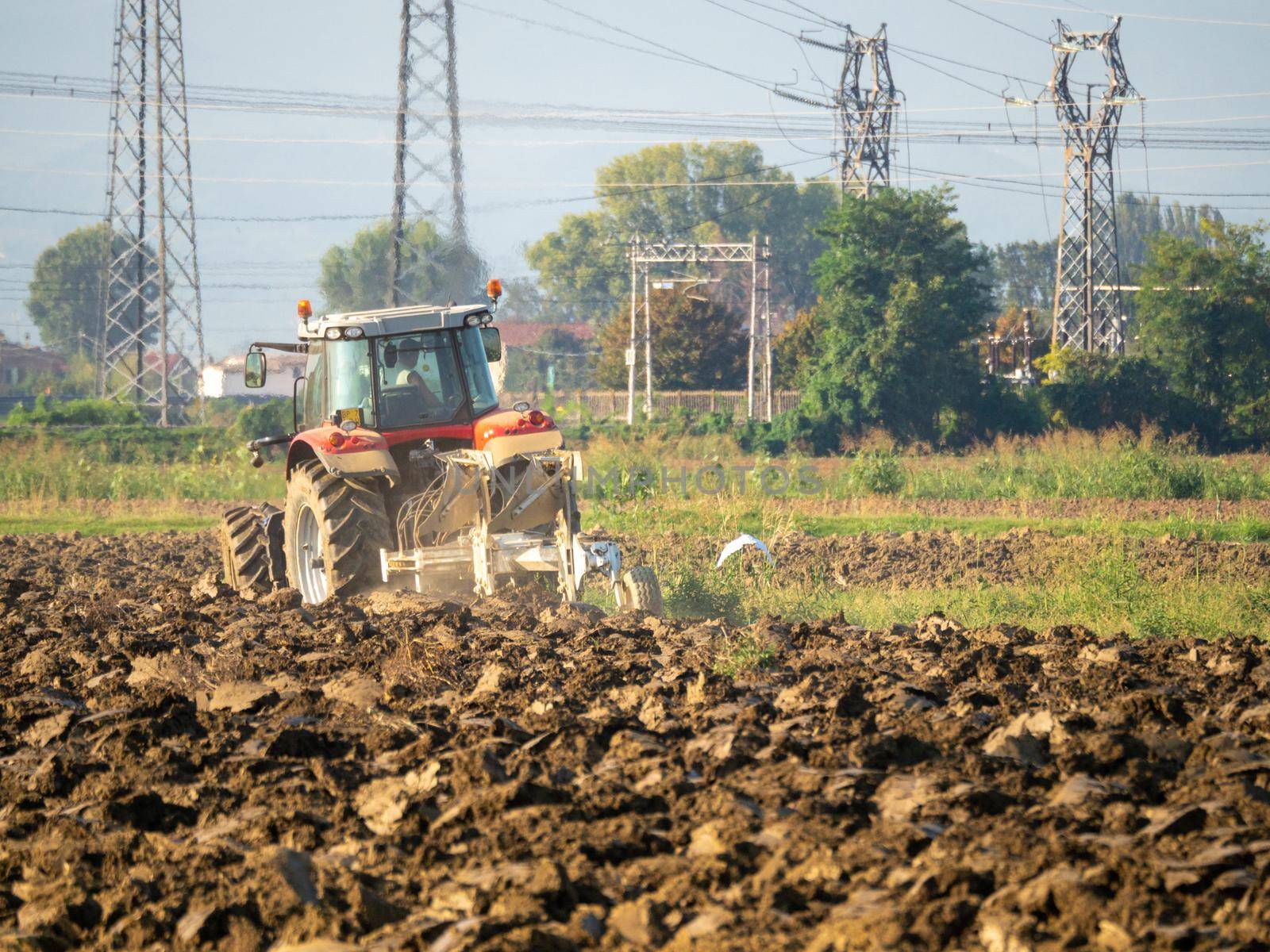 farmer with tractor plowing the land in the countryside.