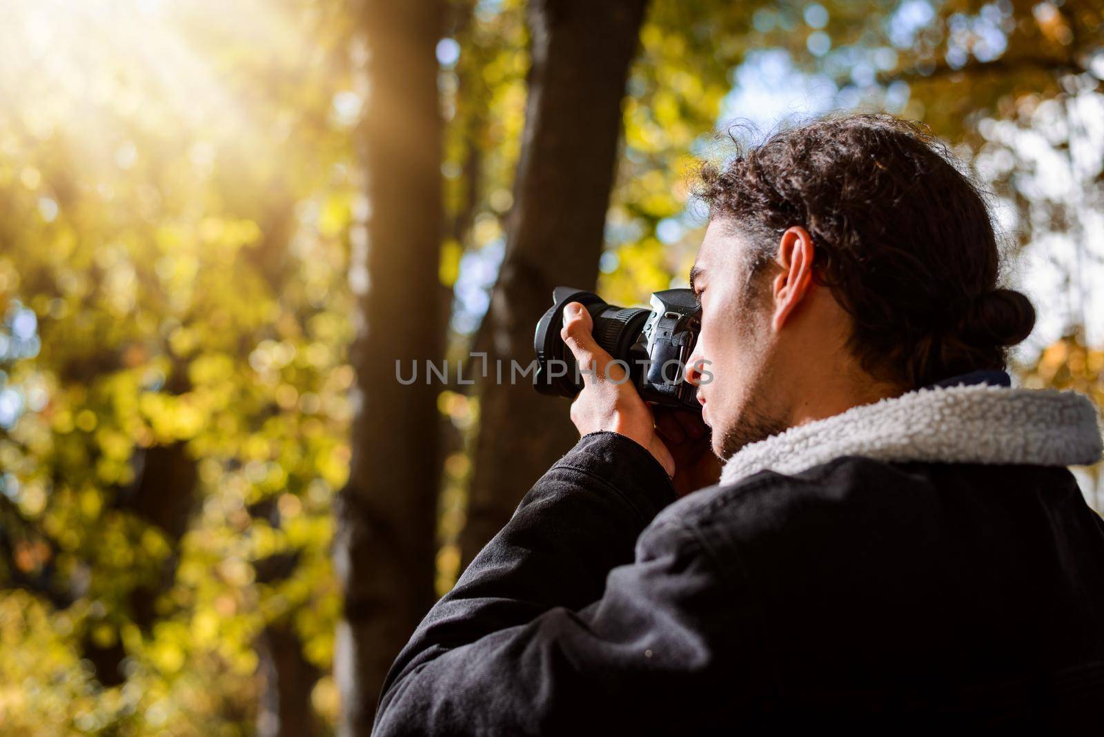 Young man taking pictures in the Autumn park by VitaliiPetrushenko