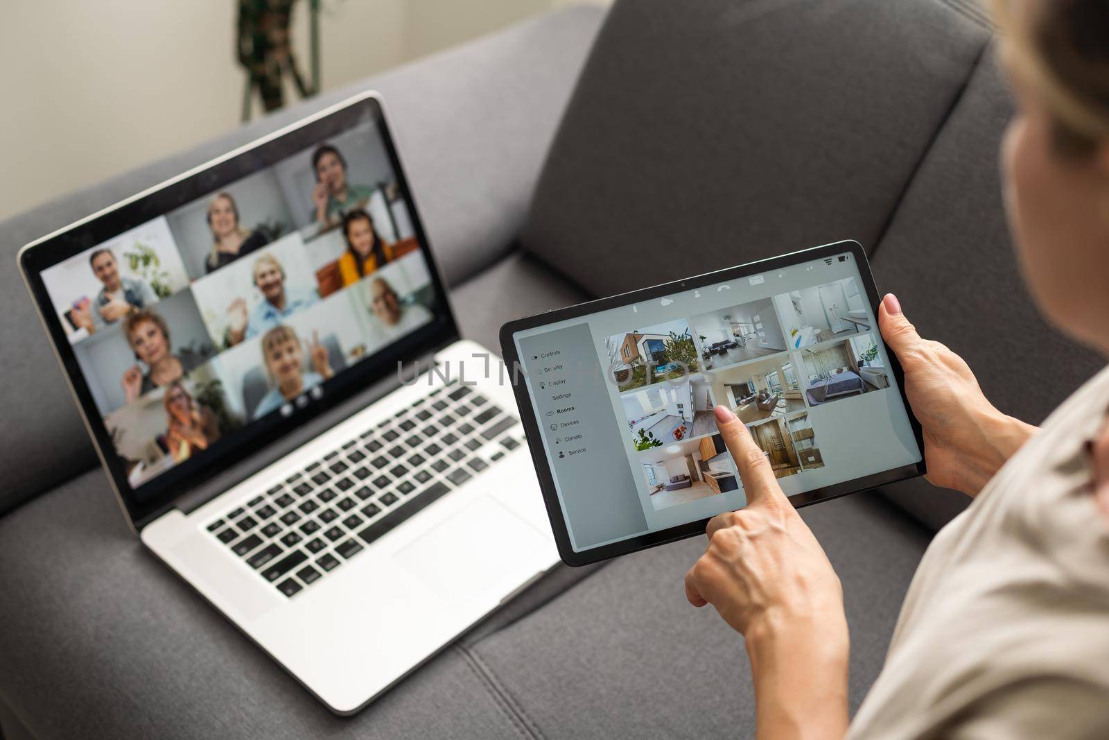 Young woman enjoying video conversation via laptop with eldery mother while sitting on sofa during self isolation for coronavirus prevention. by Andelov13