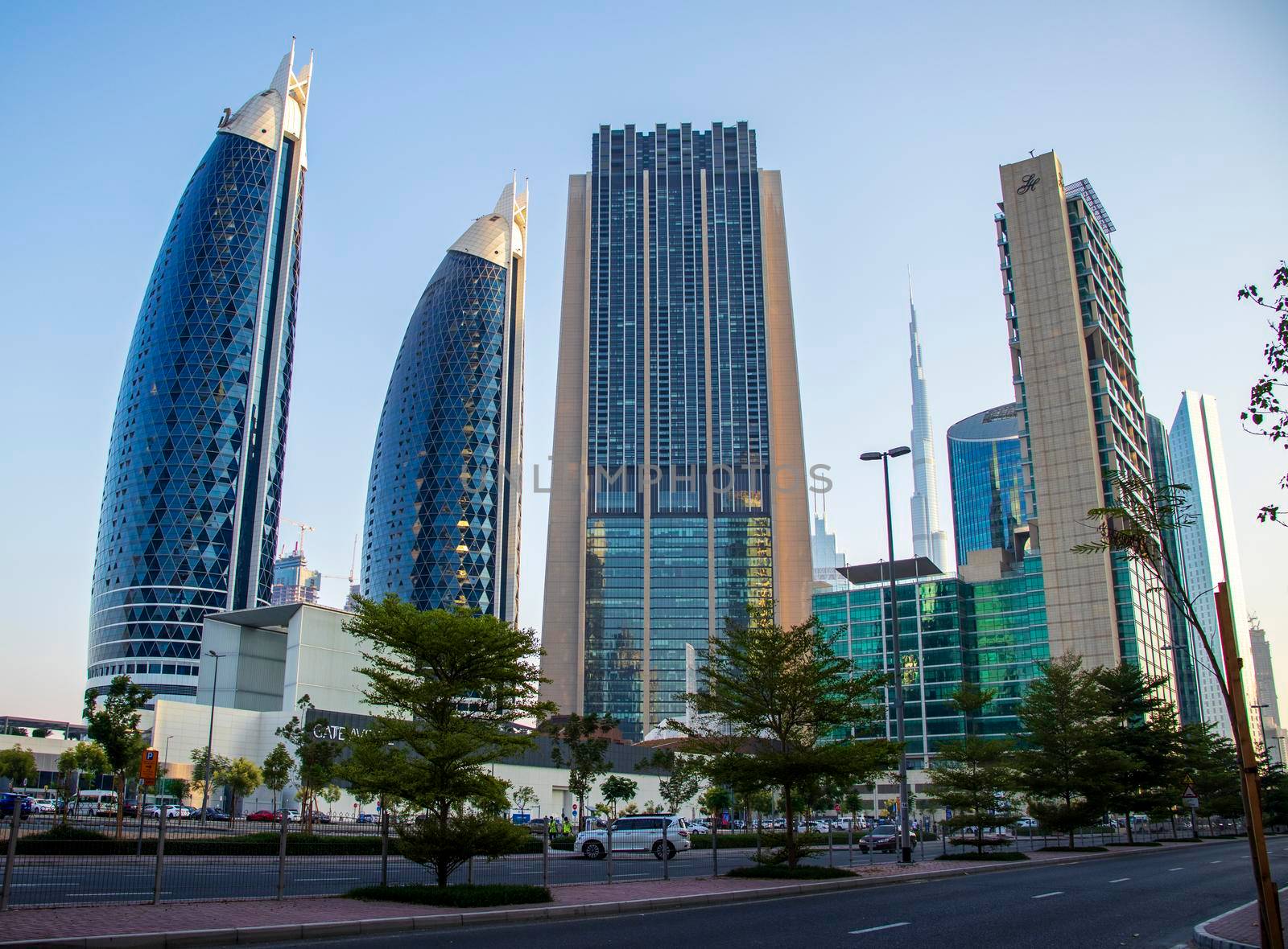 Dubai Financial Center road. Landmarks such Burj Khalifa, tallest building in the world, Index tower, Park towers can be seen on the scene. Outdoors