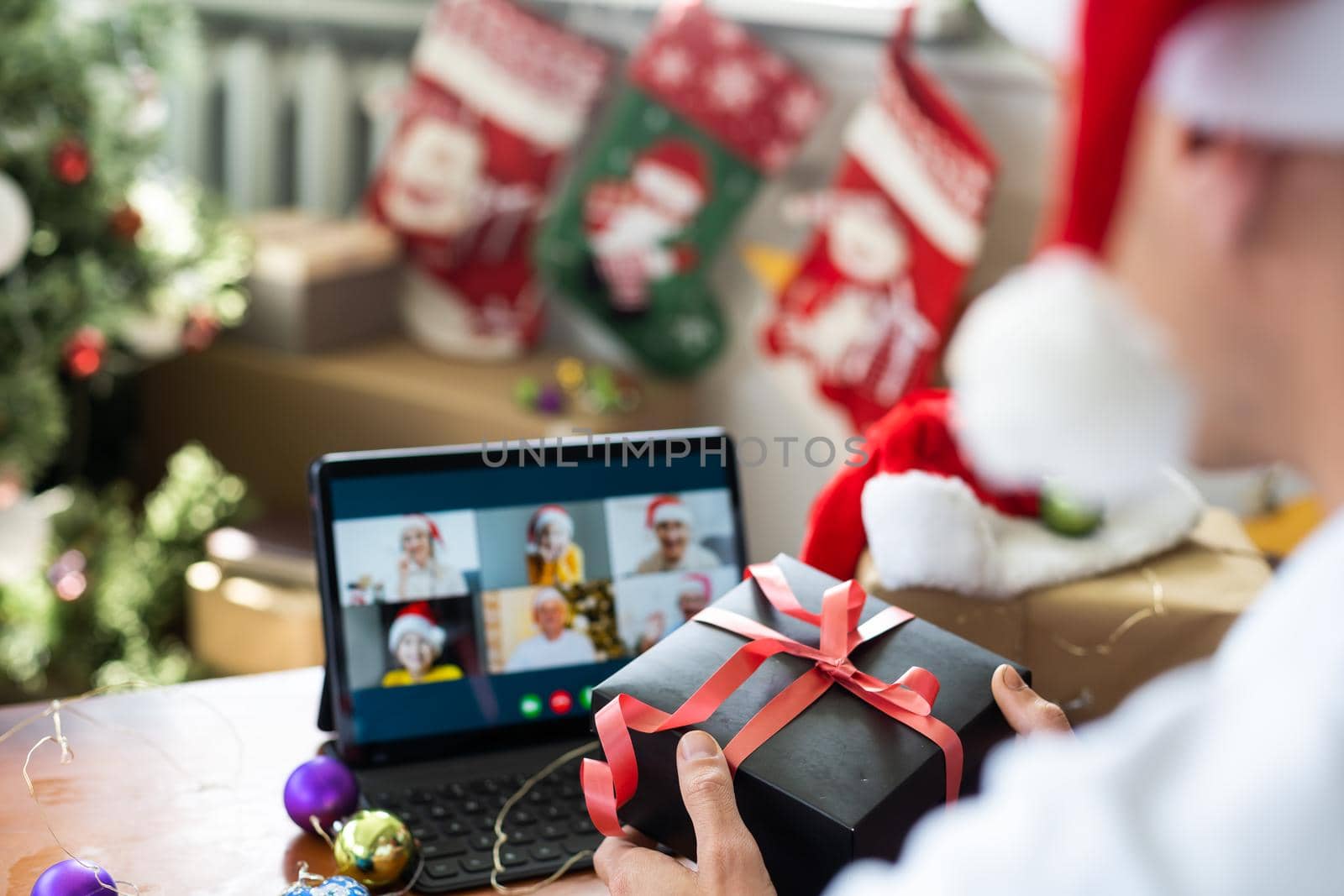 Man connecting with family during Christmas time online having video call. by Andelov13