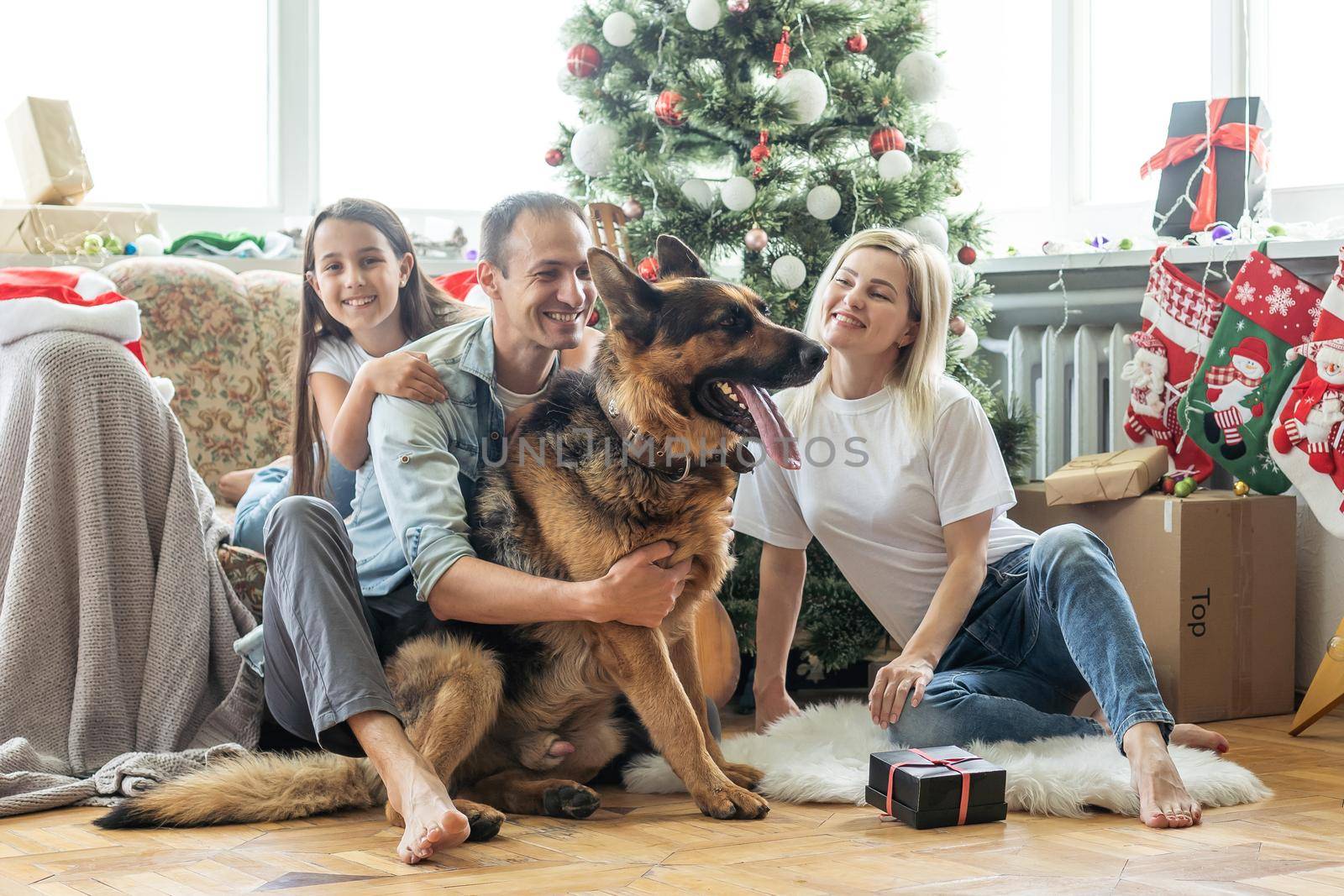 happy family and cute dog having fun at christmas tree. atmospheric emotional moments. merry christmas and happy new year concept. by Andelov13