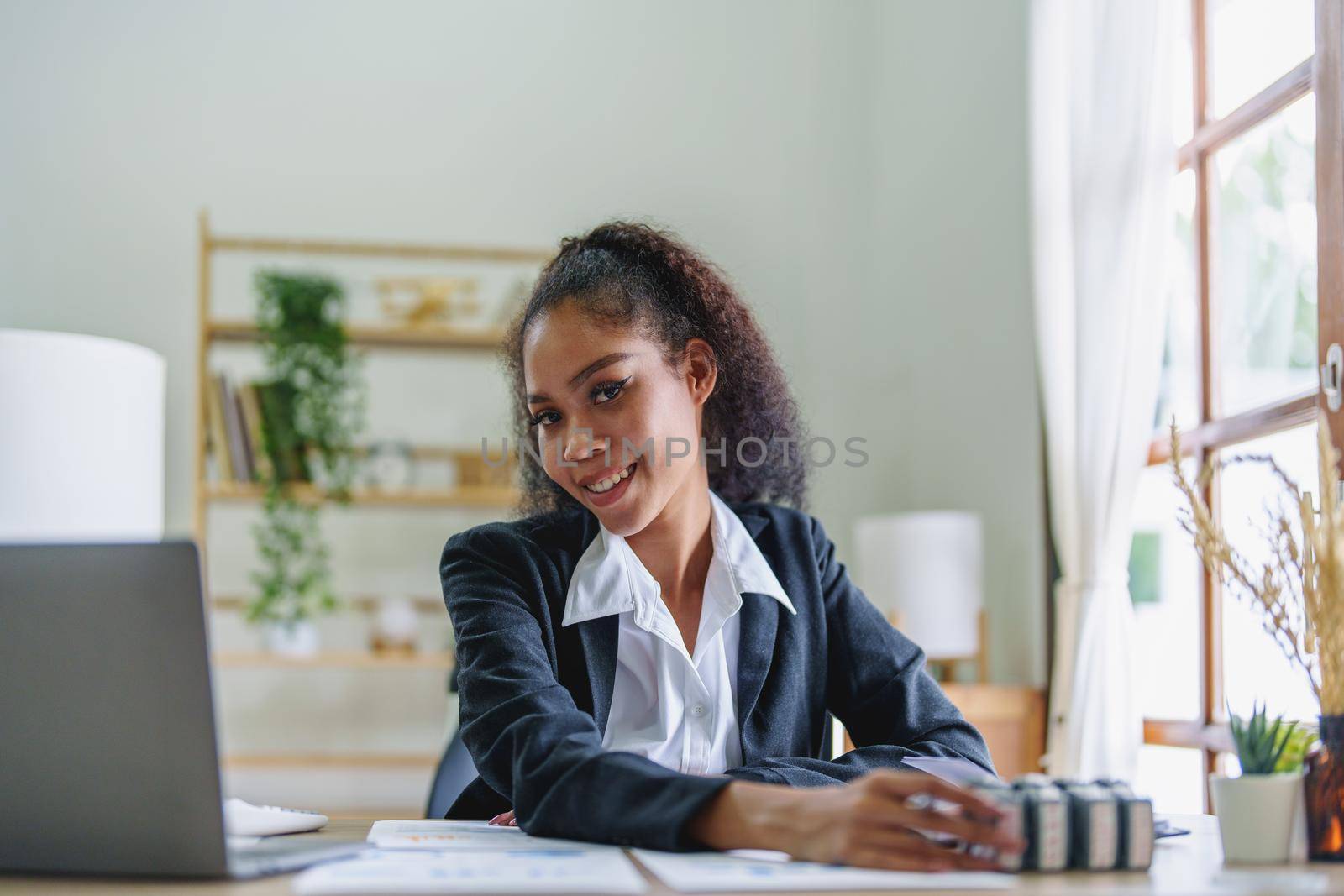 A portrait of an African Americans businesswoman showing a smile on her face as she works to increase the profits of her own business