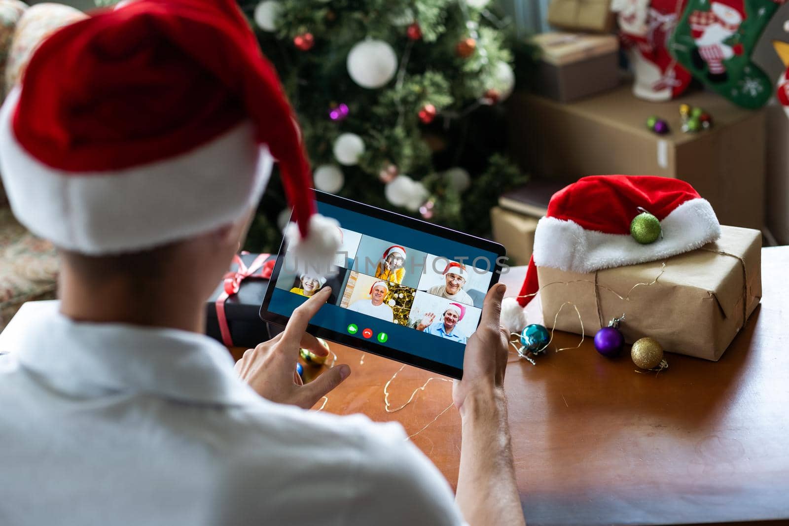 Man connecting with family during Christmas time online having video call. by Andelov13