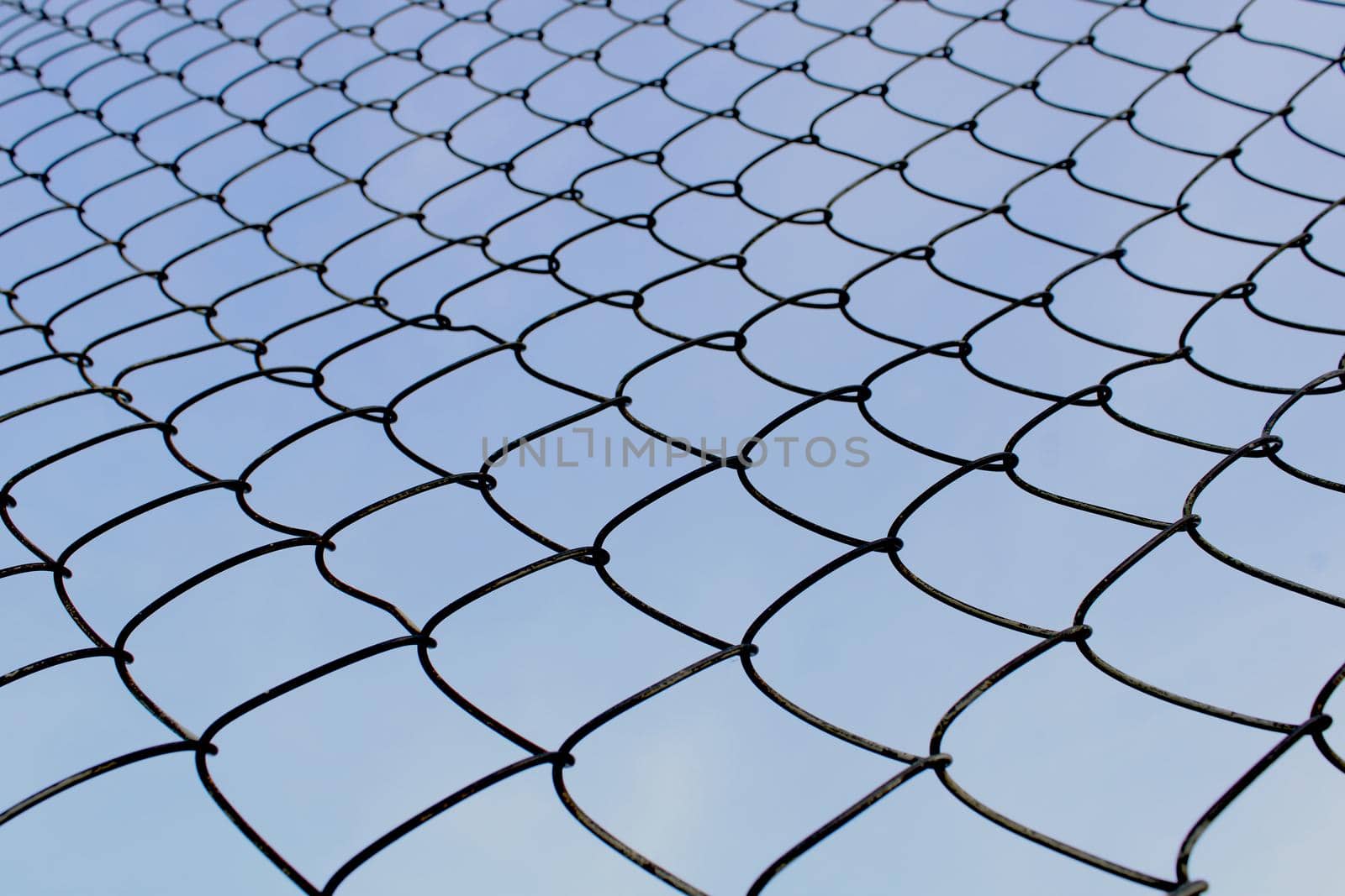 Metal mesh close-up against the blue sky. The concept of freedom and peace.