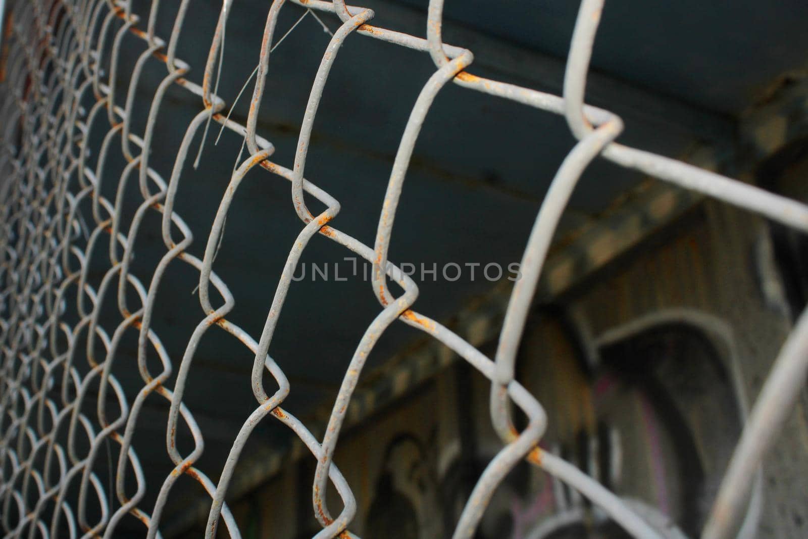Rusty metal mesh close-up on the background of painted walls.