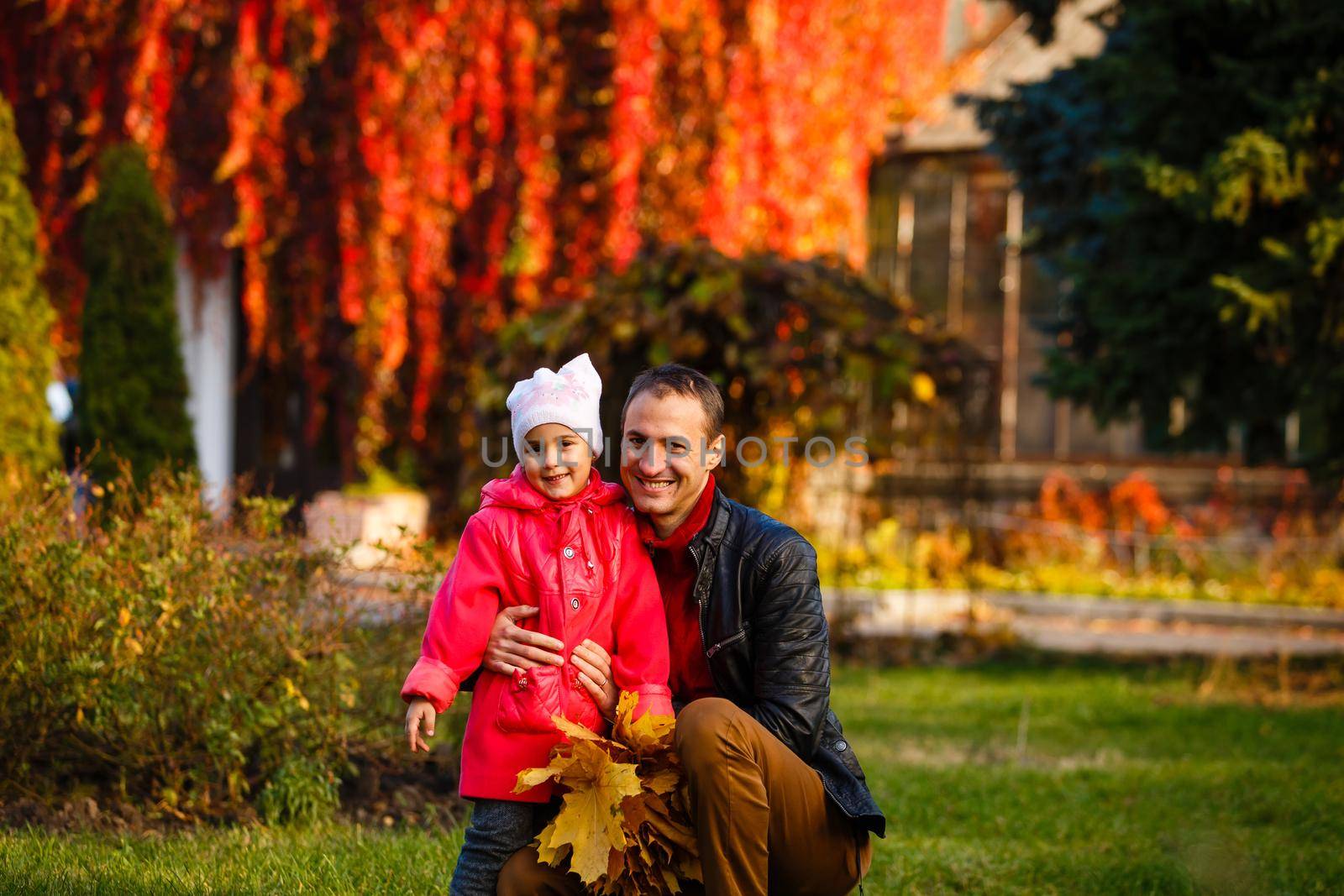 Young handsome father holding his little daughter in a sunny autumn forest. Father's day. Father's love