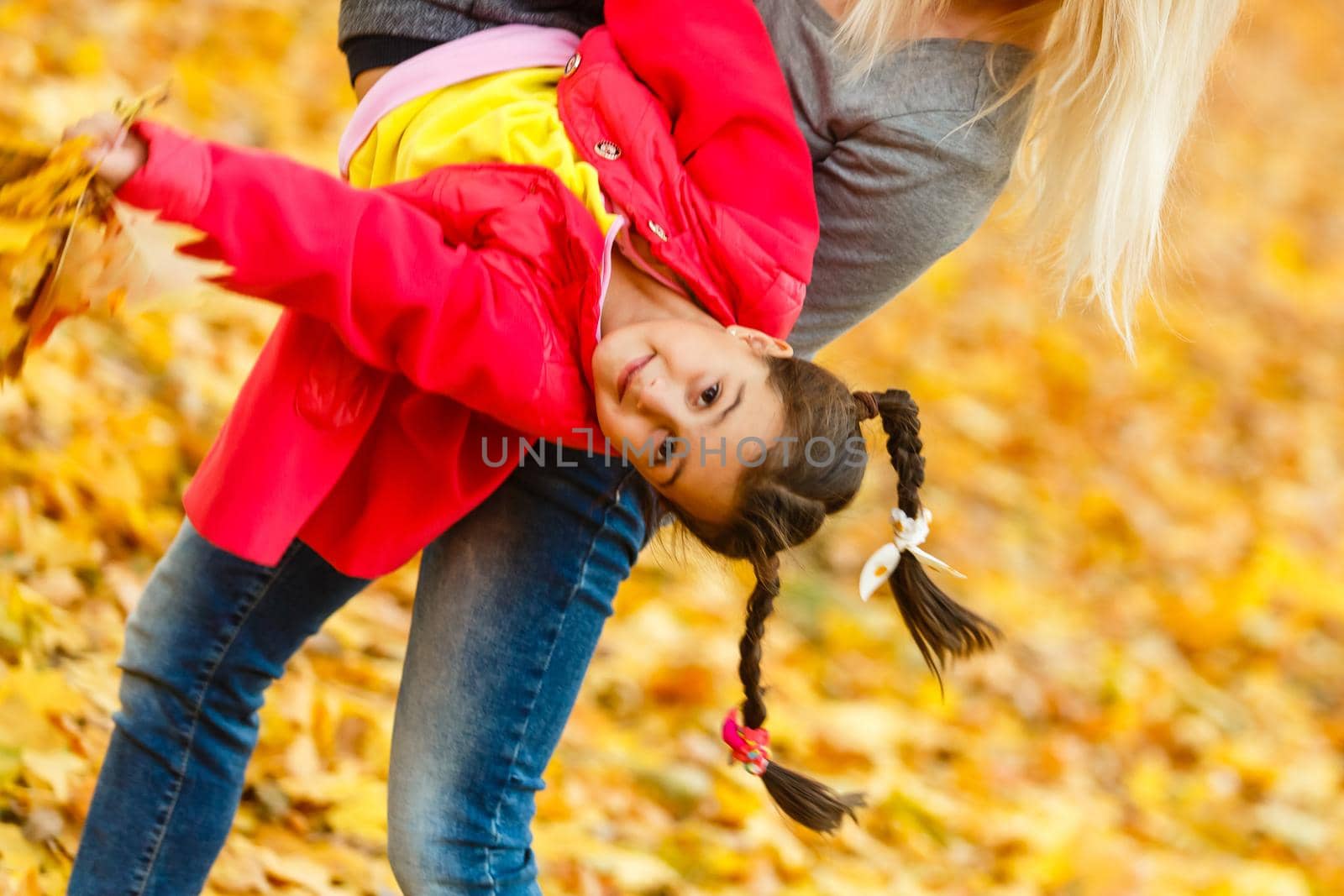 mother and daughter in the city park in autumn having fun time