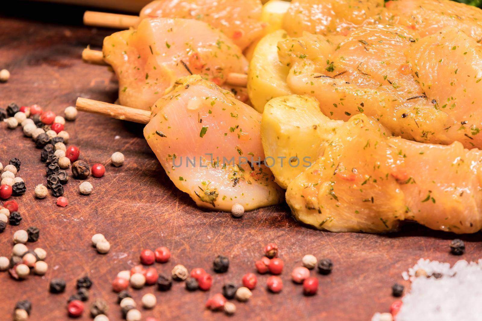 raw chicken skewers marinated with lemon on a wooden board